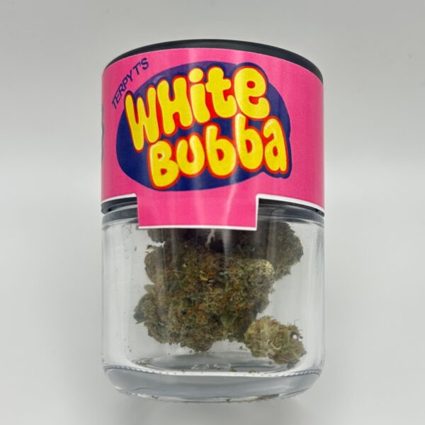 An eighth of the THCA flower White Bubba in a glass jar from Dama Botanicals.