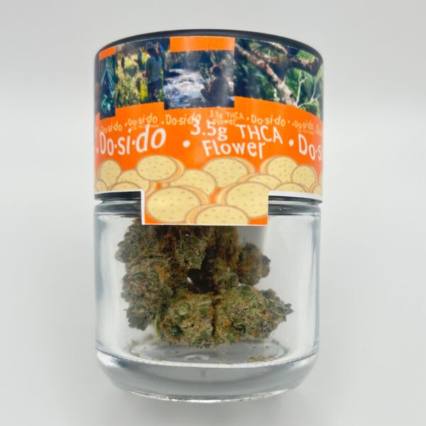 An eighth of the THCA flower strain Dosidos in a glass jar from Dama Botanicals.