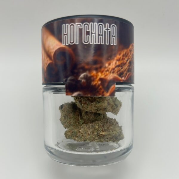 An eighth of THCA Flower in the strain Horchata displayed in a glass jar.